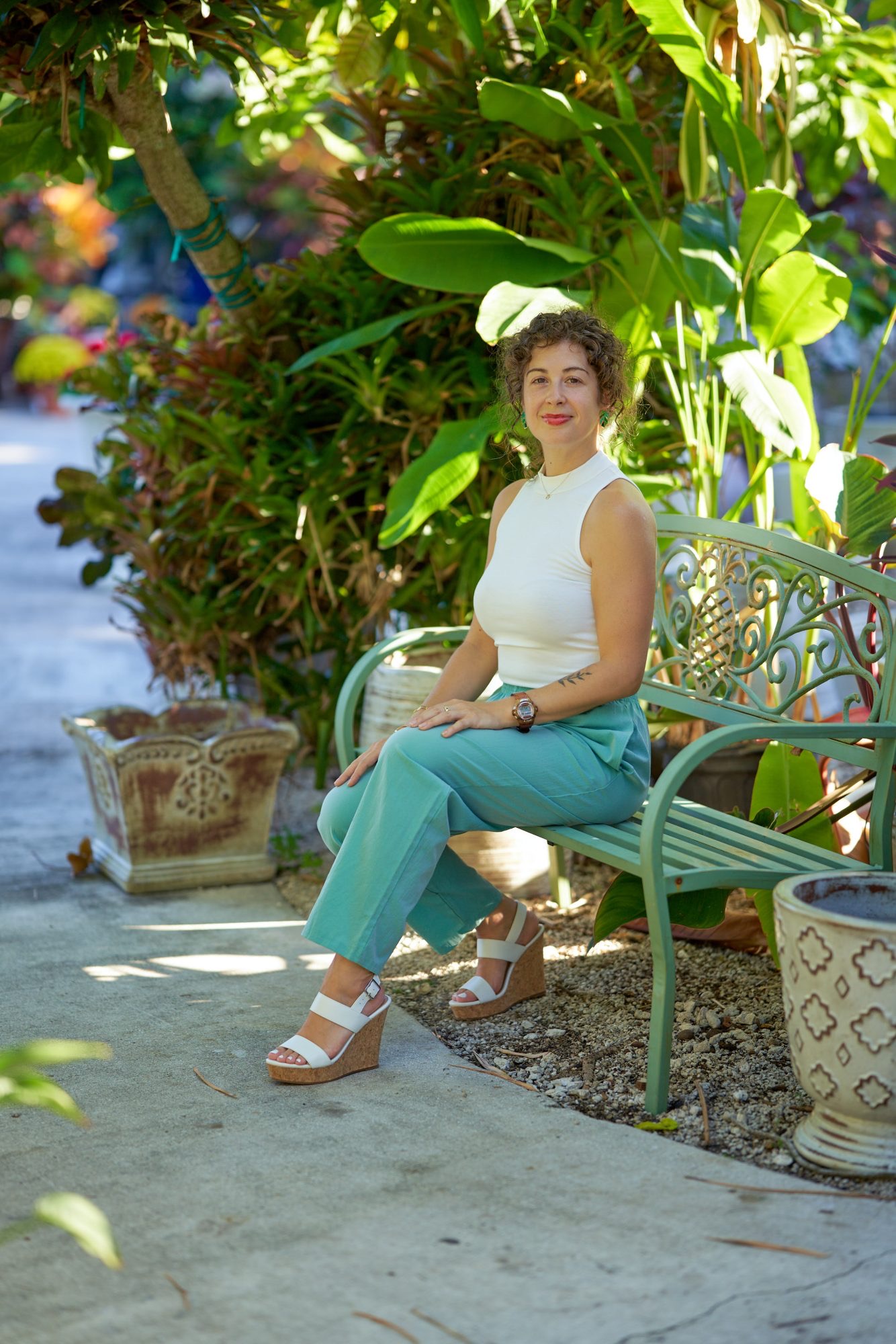 Caitlin seated among lush garden plants